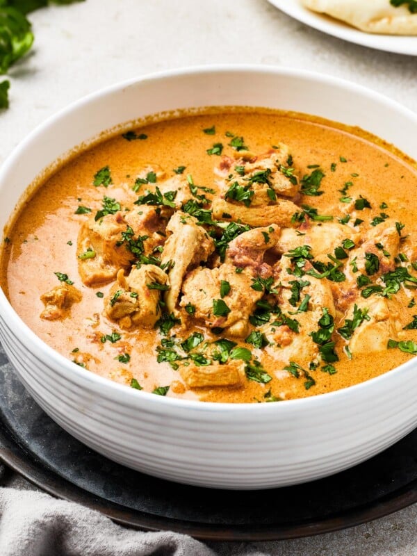 Chicken curry in a white enamel bowl.