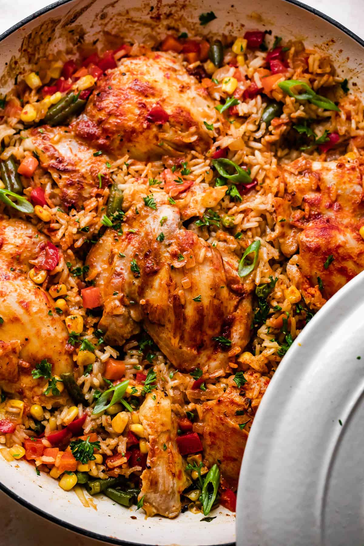 overhead shot of a round casserole dish with ranch chicken thighs, rice, and vegetables.