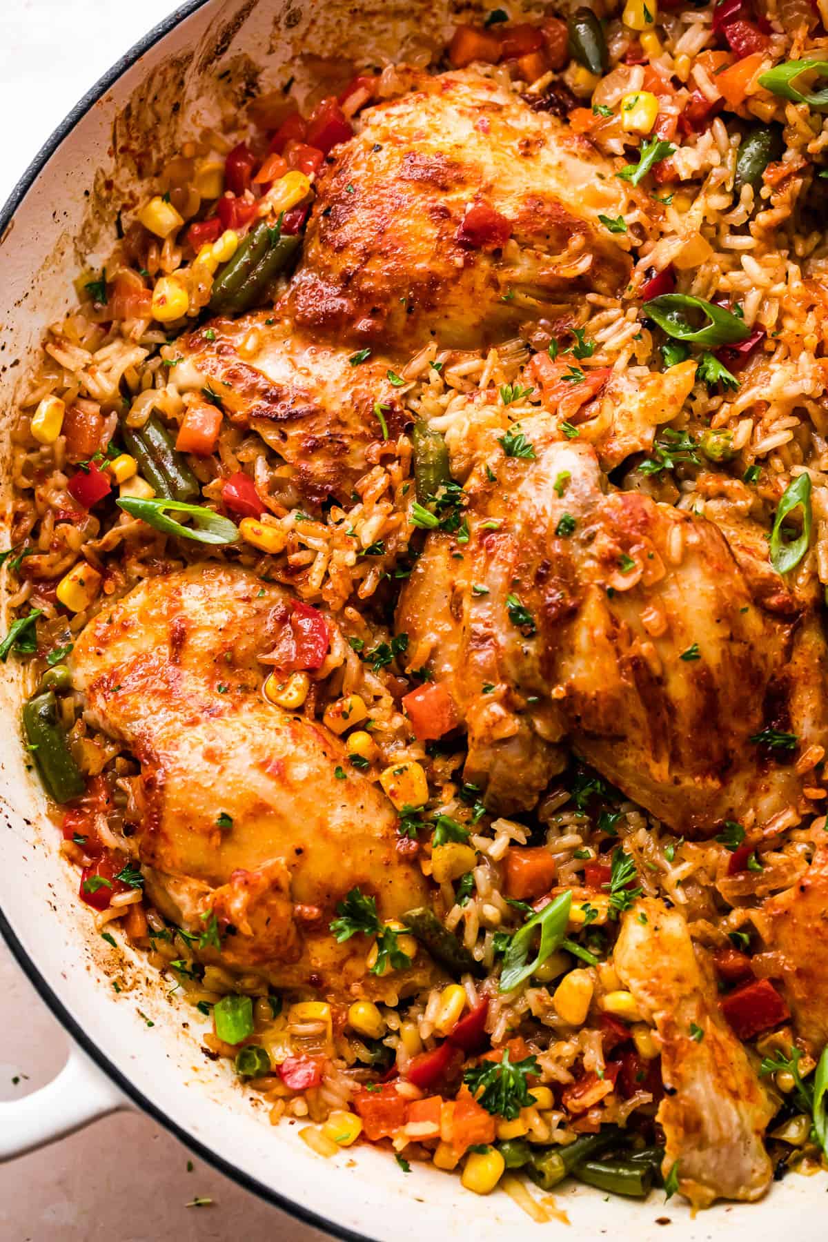 overhead shot of a round casserole dish with ranch chicken thighs, rice, and vegetables.