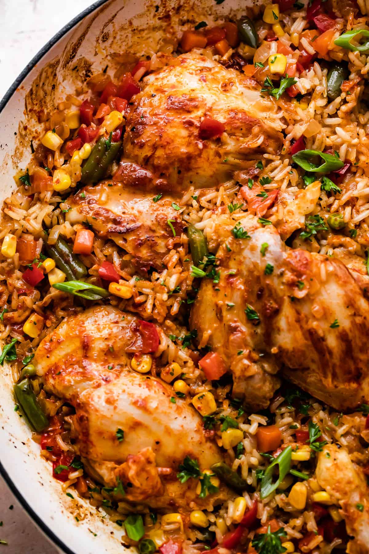 close up overhead shot of a round casserole dish with ranch chicken thighs, rice, and vegetables.