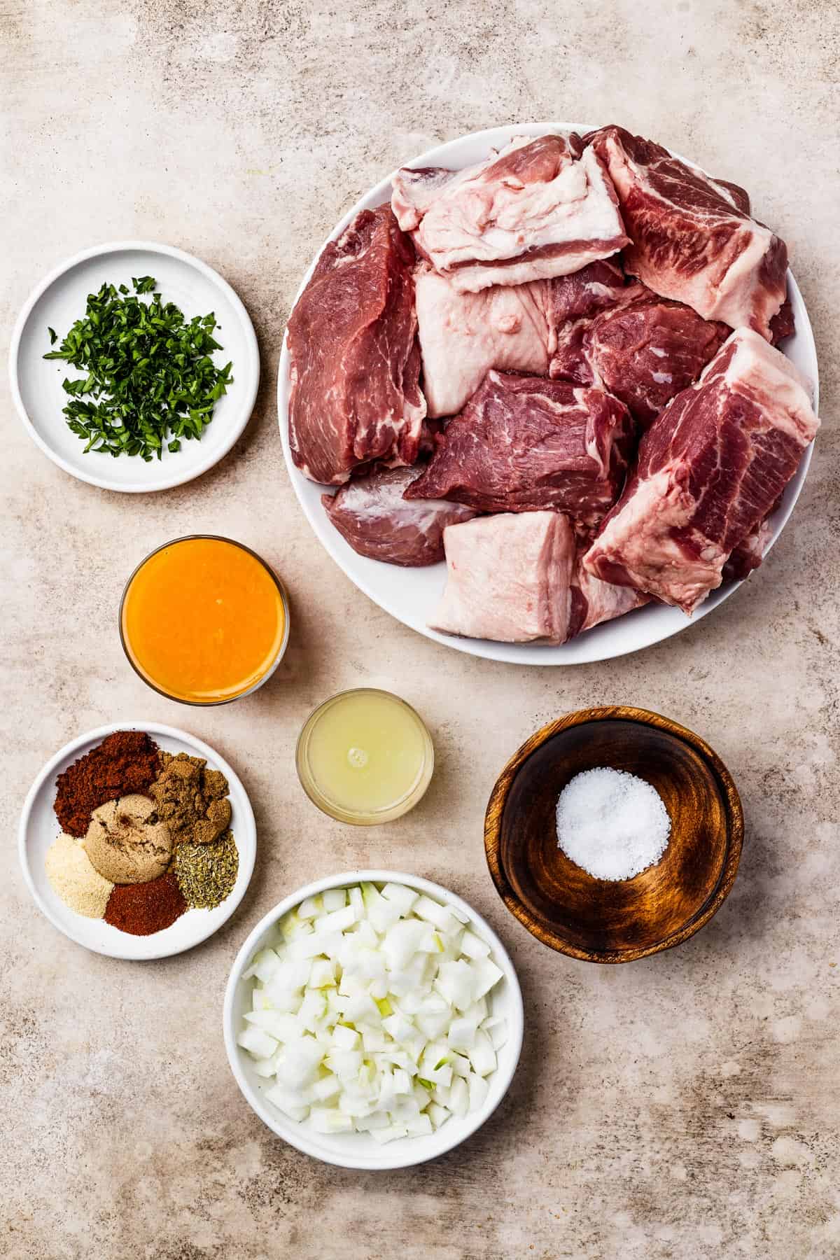 From top left: Chopped cilantro, pork butt, orange juice, lime juice, seasonings, salt, white onion.