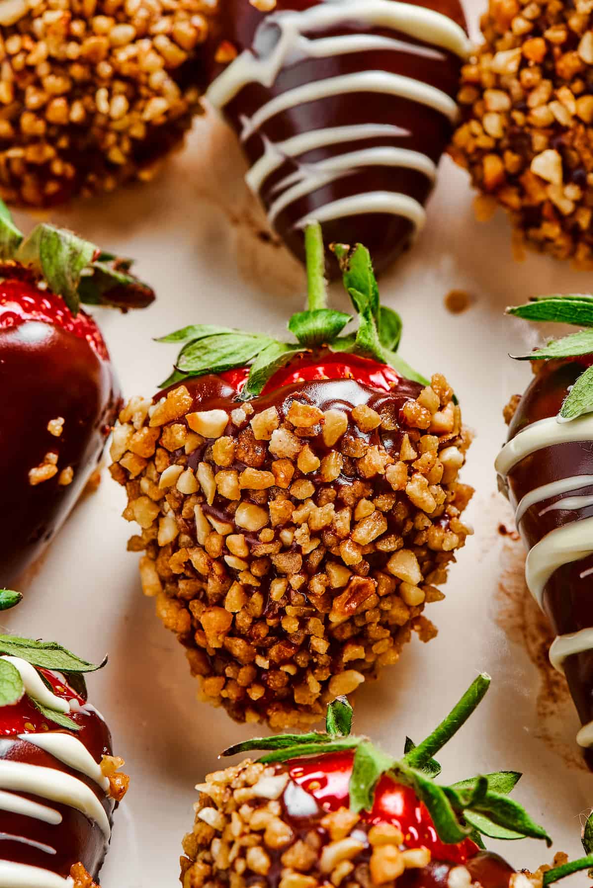 A strawberry dipped in chocolate and coated in chopped nuts.