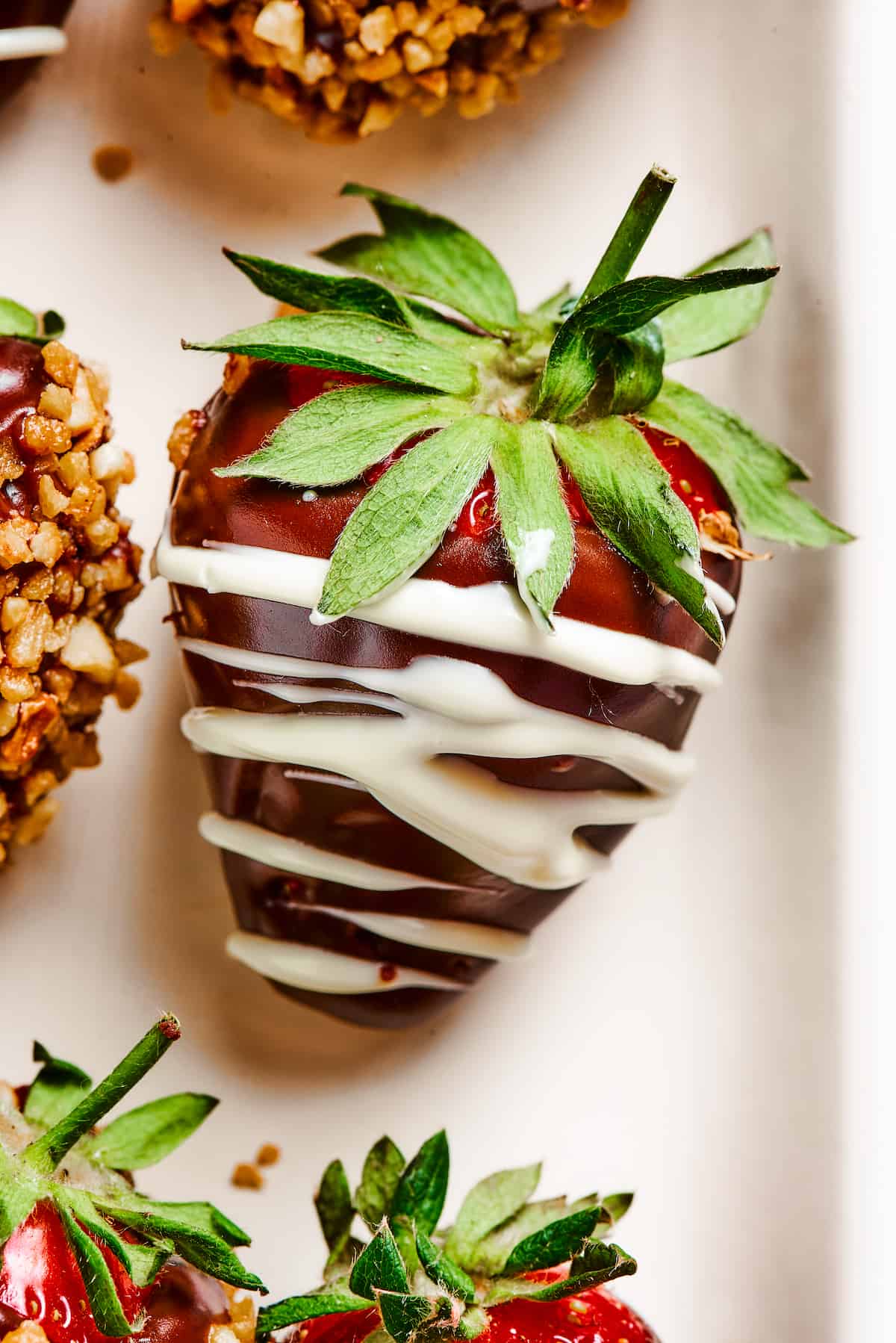 A strawberry dipped in chocolate and drizzled with white chocolate.