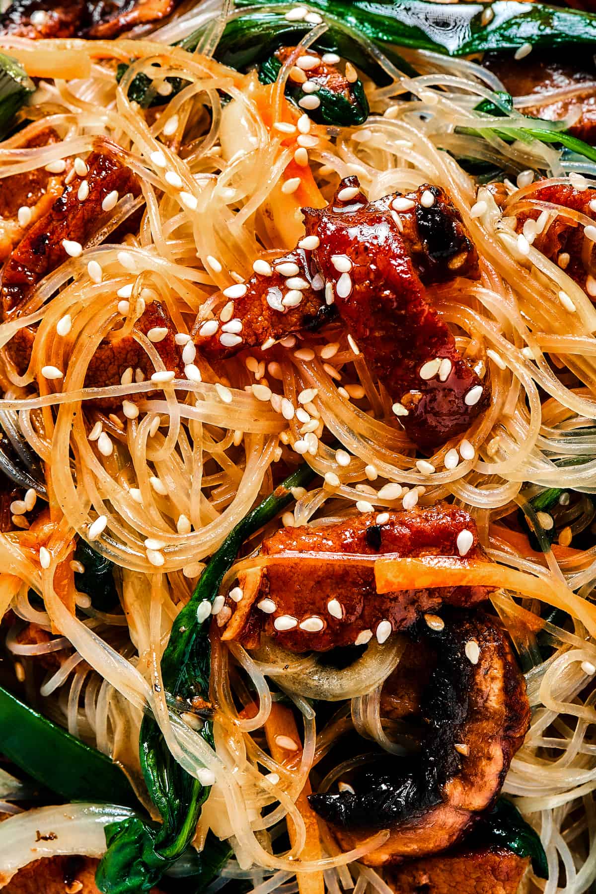 close up shot of Japchae garnished with sesame seeds.