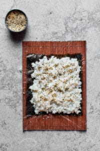 A sheet of nori with sushi rice spread over it.