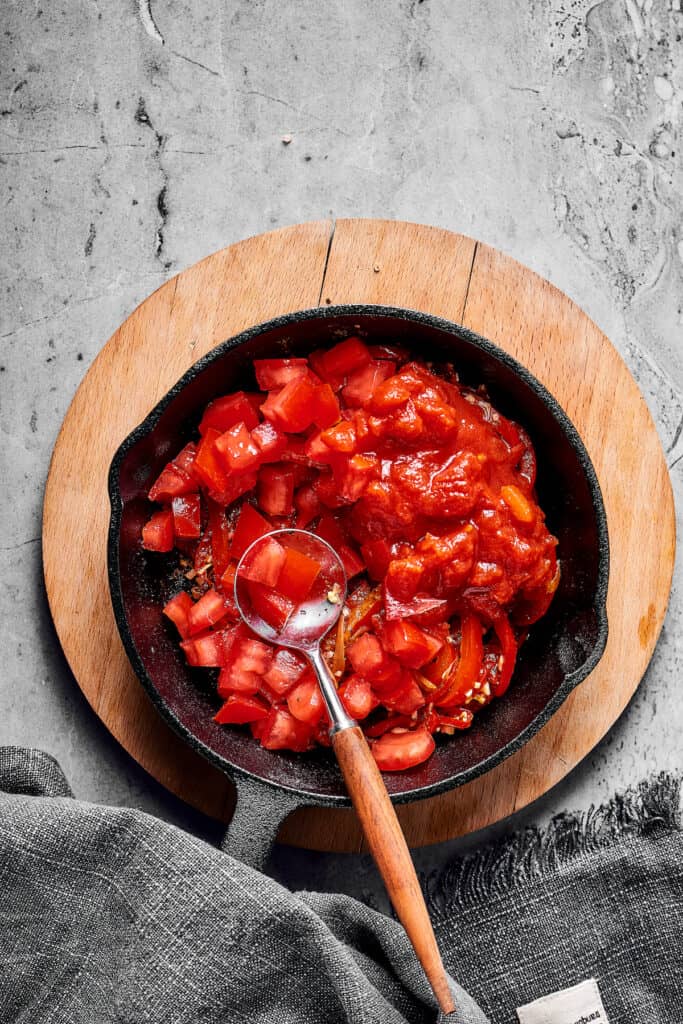 Tomatoes, bell pepper, and onion in a skillet.