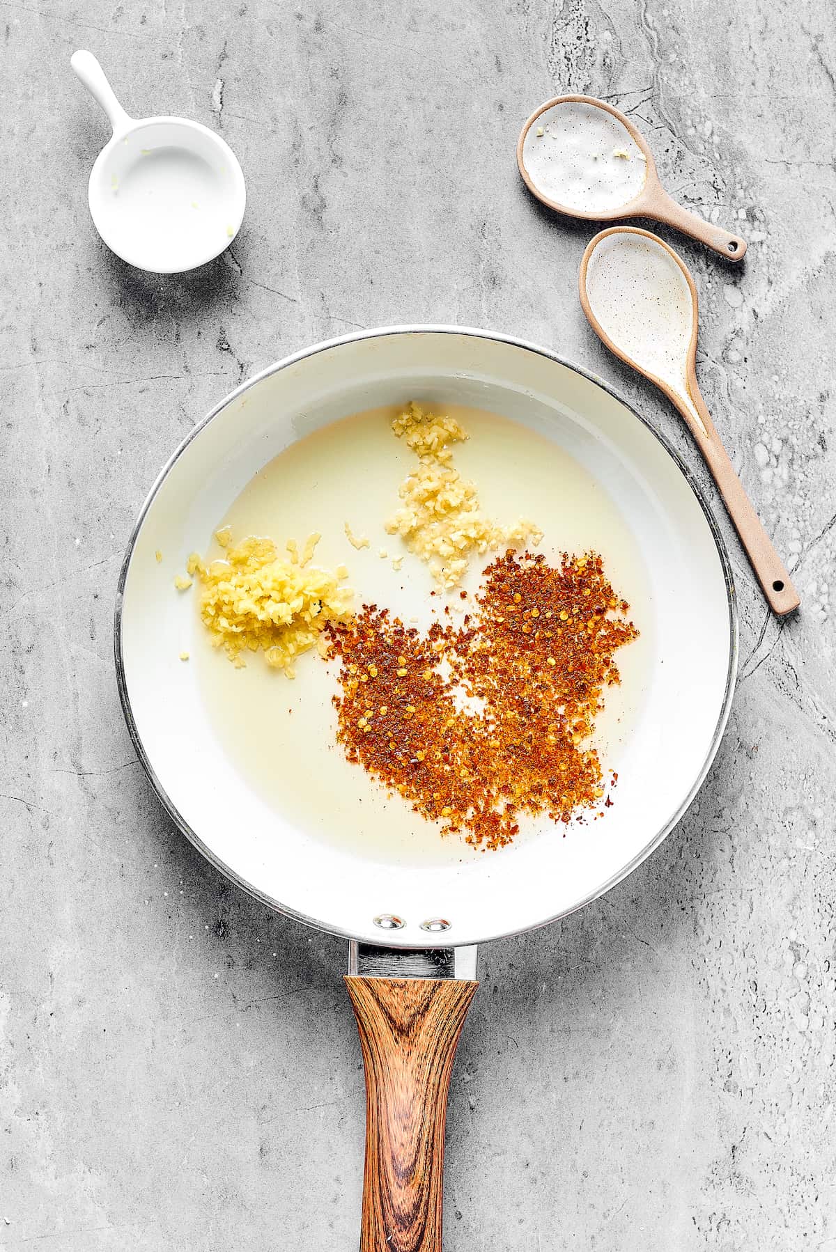 Spices and aromatics in a skillet.