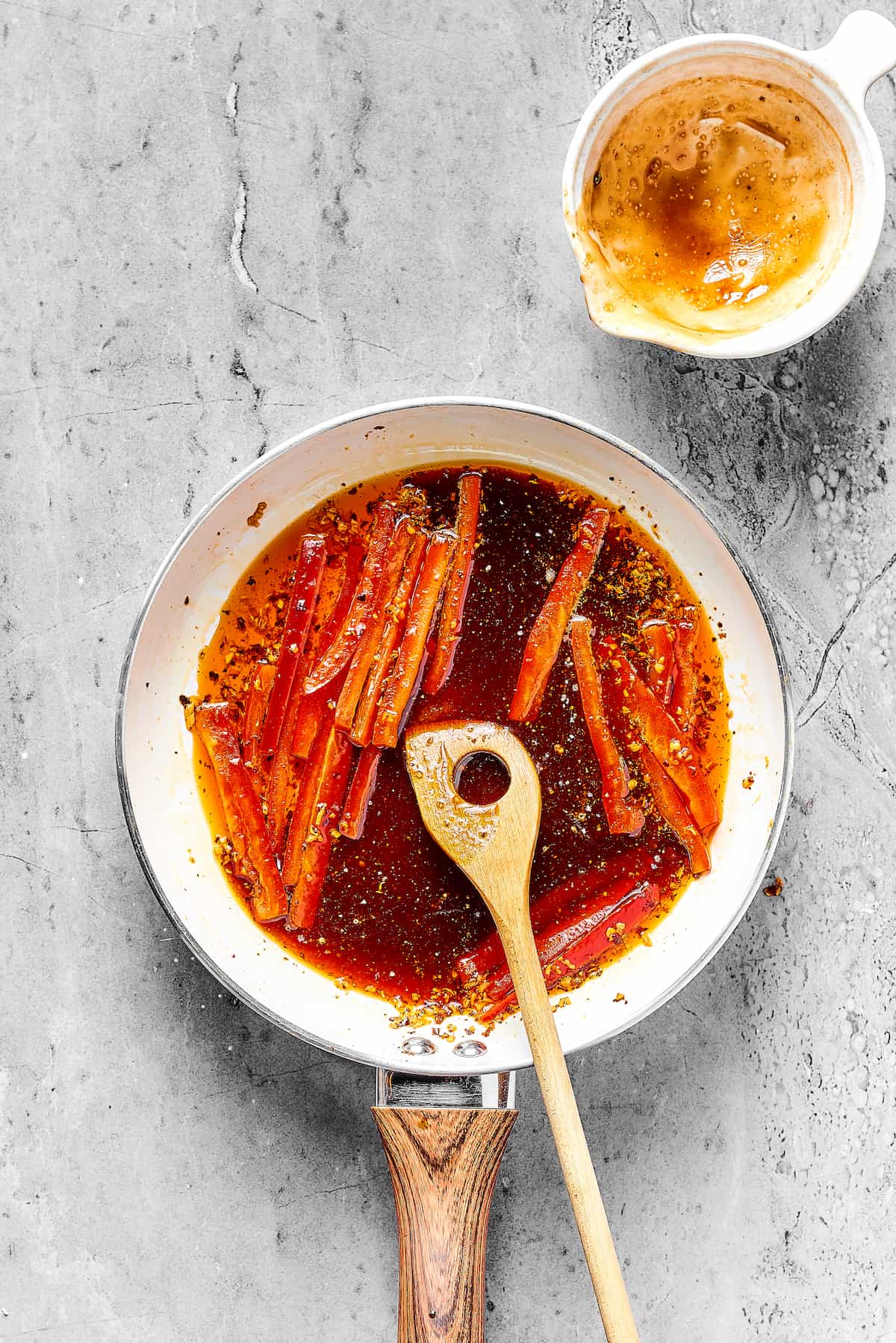 Bell pepper strips cooking in a skillet of reddish sauce.