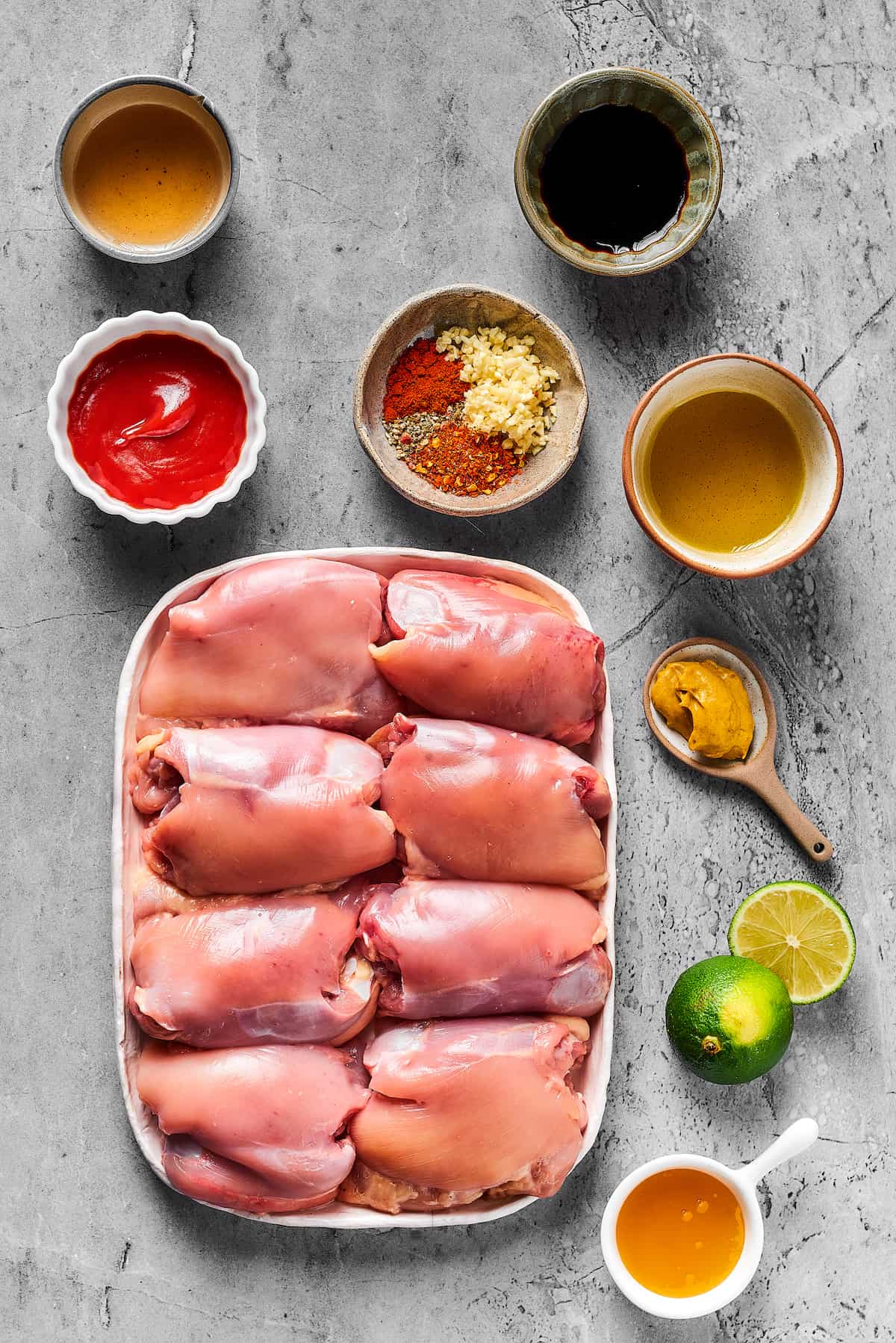 From top left: Olive oil, soy sauce, ketchup, seasonings, honey, dijon mustard, lime, rice vinegar, chicken thighs.