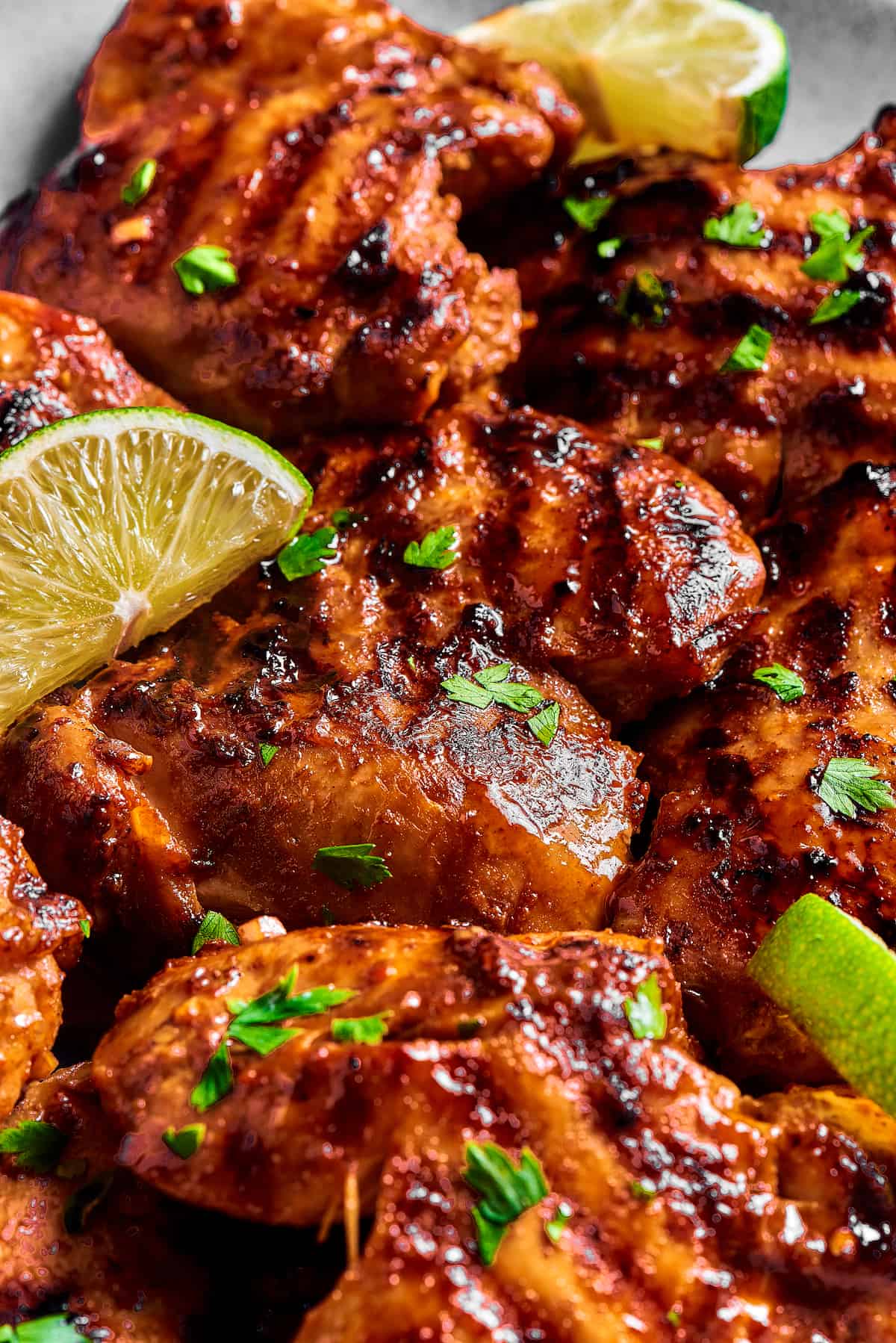 Close-up shot of grilled chicken, showing the grill marks and sticky sauce.