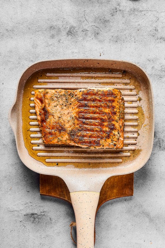 Seasoned cooked salmon on a grill pan.