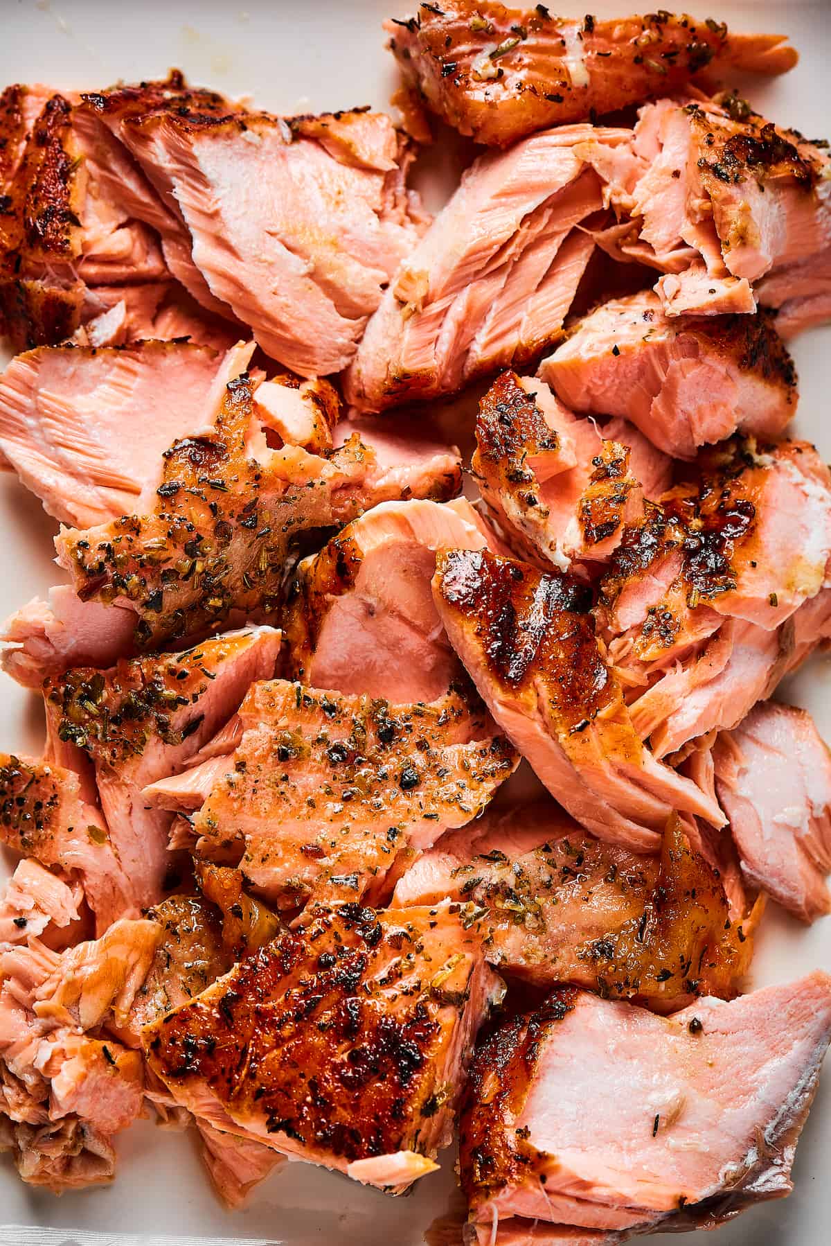 Close-up shot of cooked salmon, broken into bite-sized pieces.