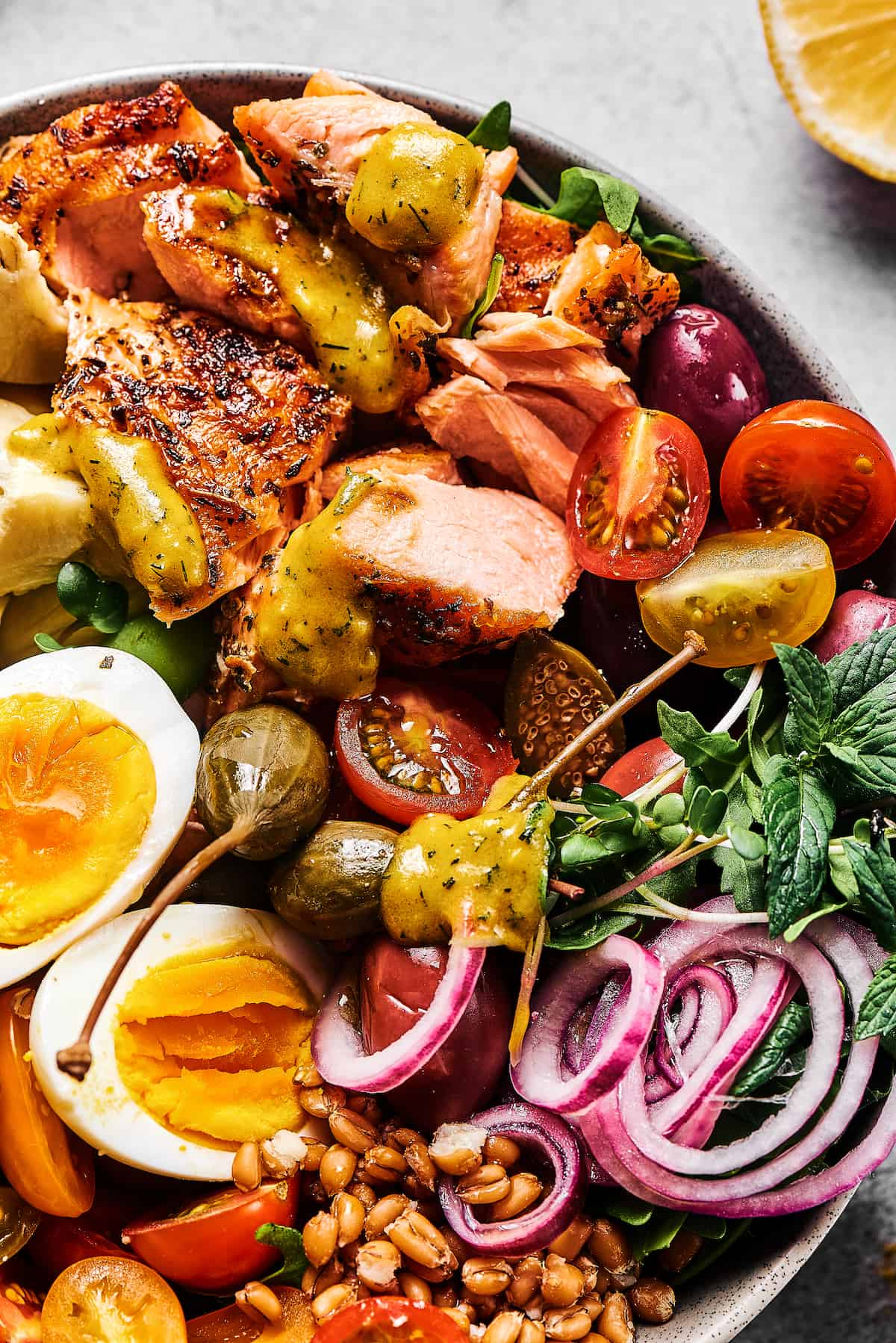 A main-course salad with grilled salmon, tomatoes, arugula, hard-boiled eggs, pickled onions, and more.