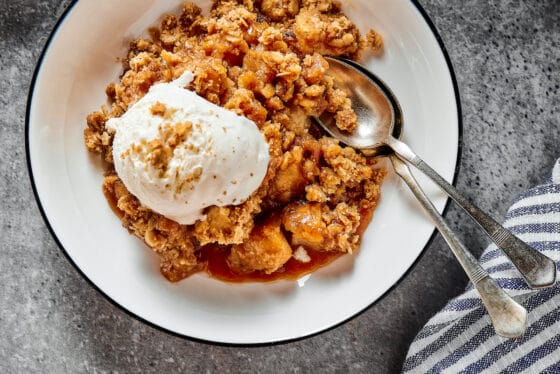 A serving of homemade apple crisp, topped with ice cream.