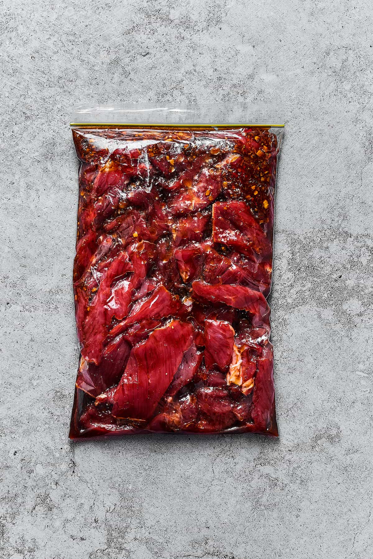 Steak and marinade in a zip-top bag.