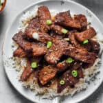 A plate of bulgogi with other dishes visible at the edges of the shot.