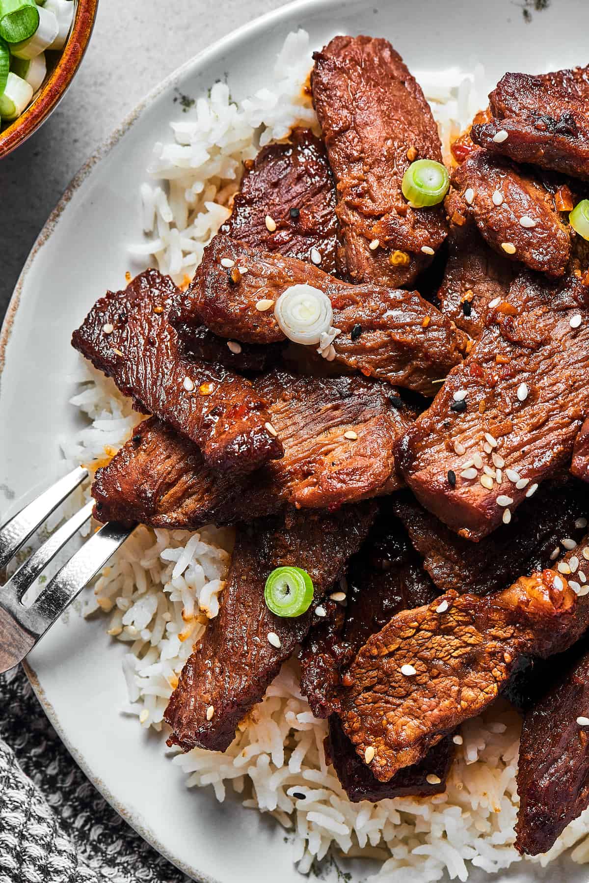 Korean BBQ steak slices on a plate of rice.