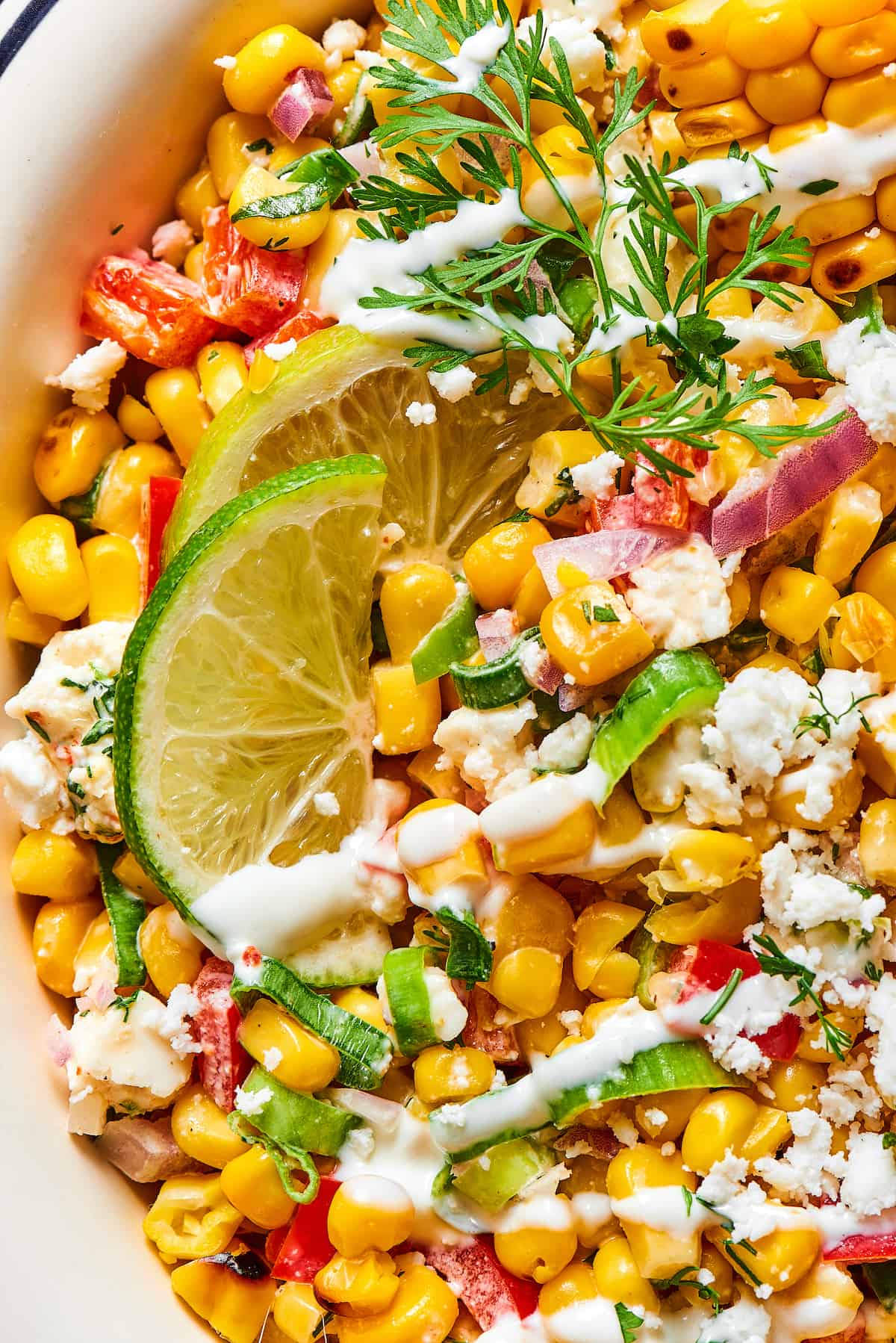 Close-up shot of Mexican street corn salad, showing the texture of the ingredients and the dressing.