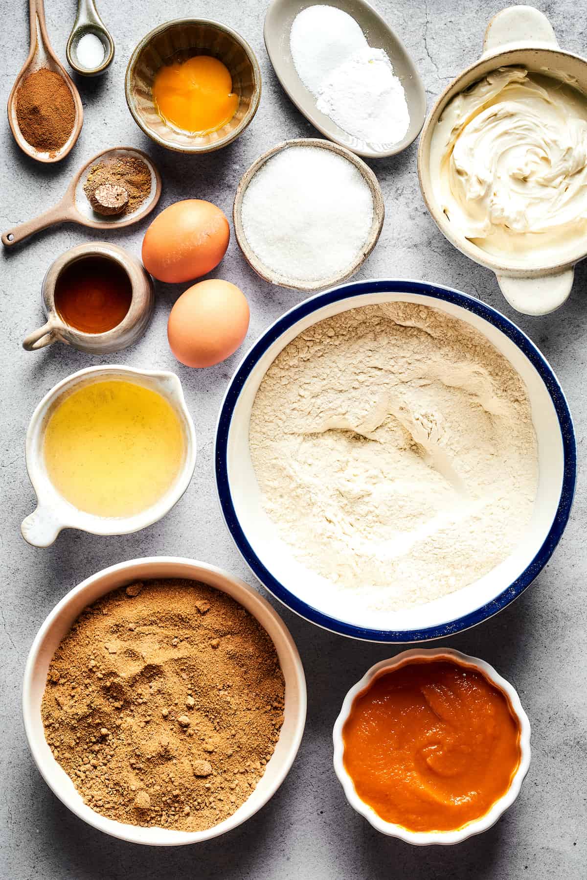 From top: Cinnamon, salt, eggs and an egg yolk, baking powder and baking soda, cream cheese, white sugar, vegetable oil, flour, brown sugar, pumpkin puree.