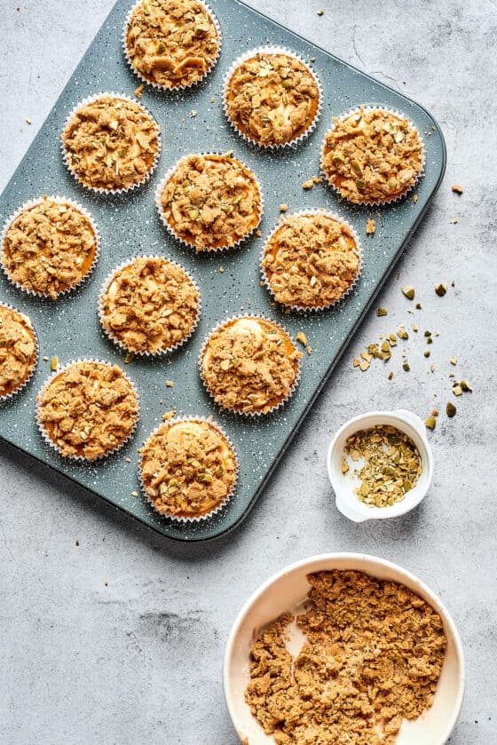 Muffins in a tin, topped with crumbly streusel.