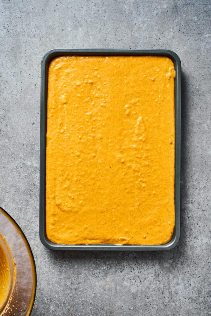 A baking dish filled with pumpkin cheesecake filling.