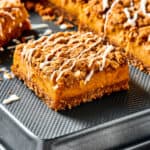 Pumpkin bars drizzled with cream cheese topping.