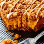 Close-up shot of a pumpkin cheesecake bar, with one corner broken off and resting on a fork.