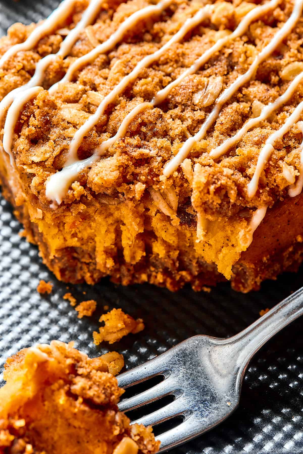 Close-up shot of a pumpkin cheesecake bar, with one corner broken off and resting on a fork.