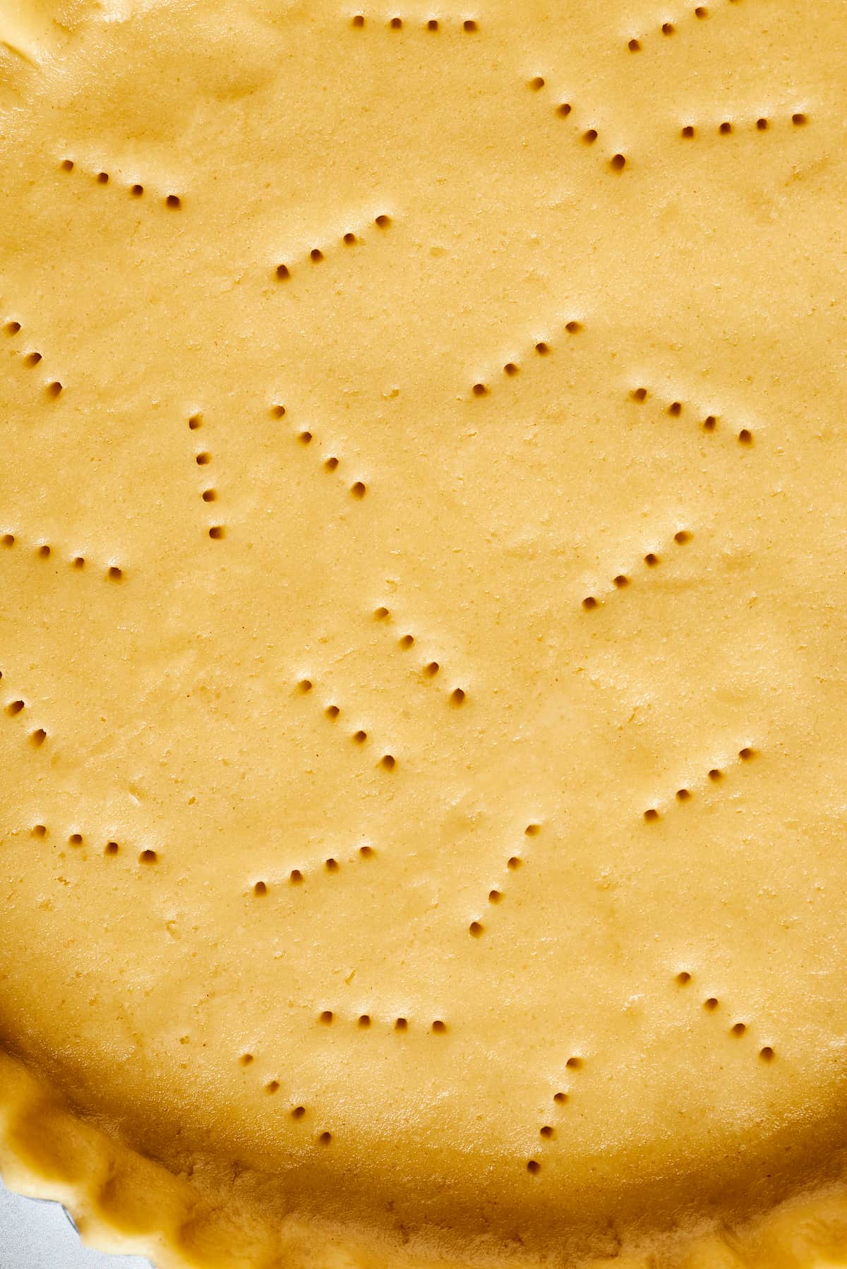 Close-up shot of pie dough pricked with a fork.