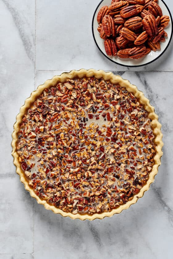 Overhead shot of a partially-assembled pecan pie. The pecan halves have not yet been added.