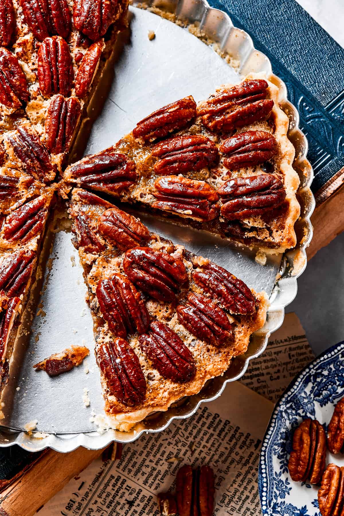 A pie dish with several slices of pecan pie left in it.