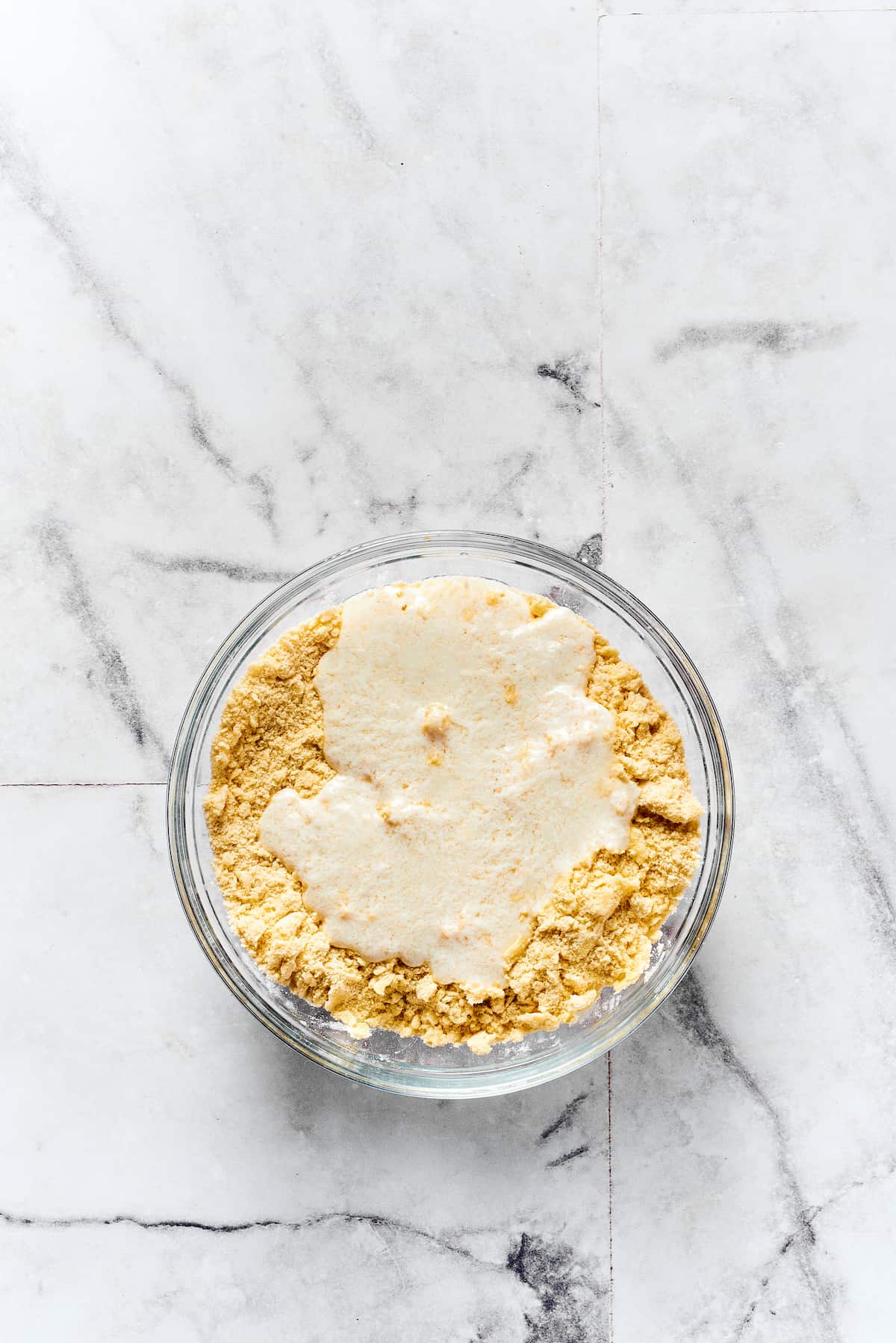 Buttermilk being mixed into biscuit dough.