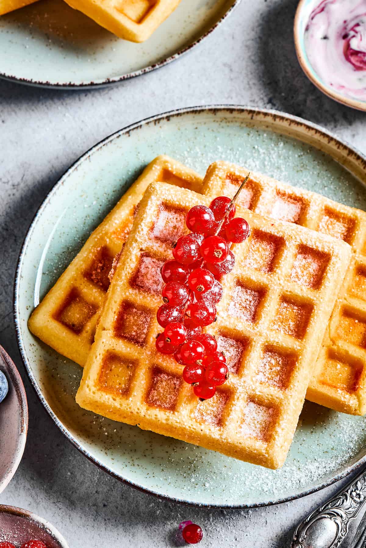 A plate of waffles garnished with fresh currants.