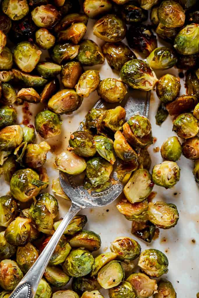 Tossing roasted brussels sprouts with glaze.