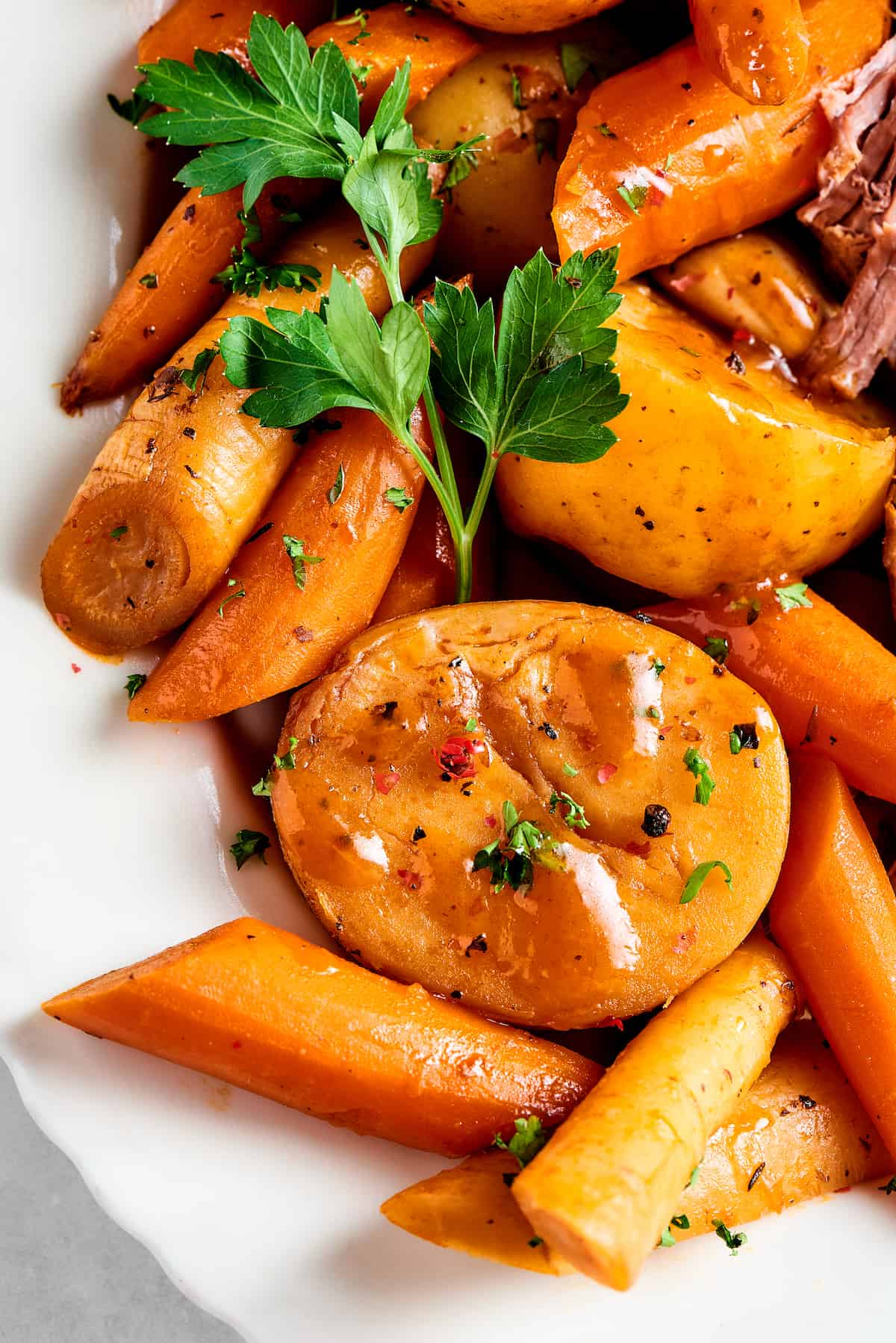 Close-up shot of cooked potatoes, carrots, and parsnips.