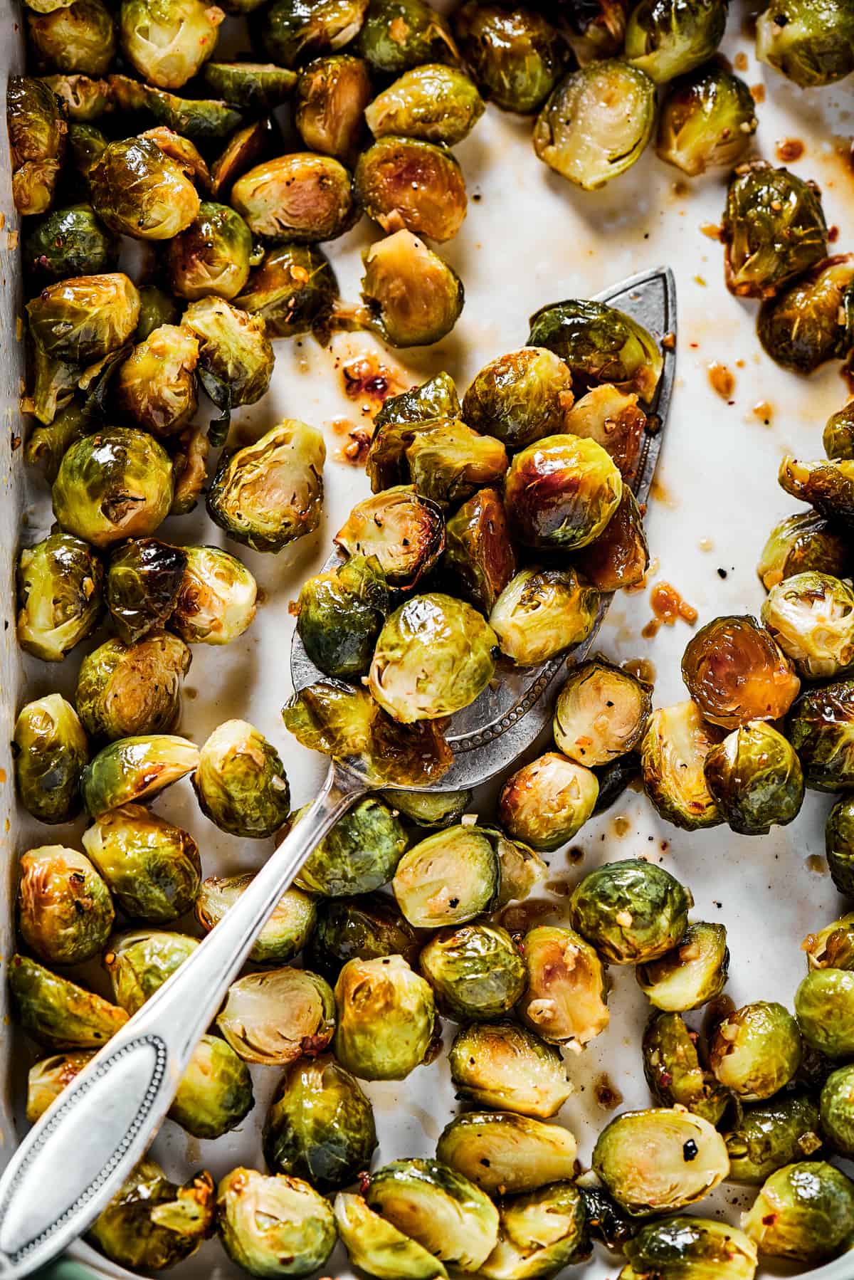 Tossing roasted brussels sprouts with glaze.