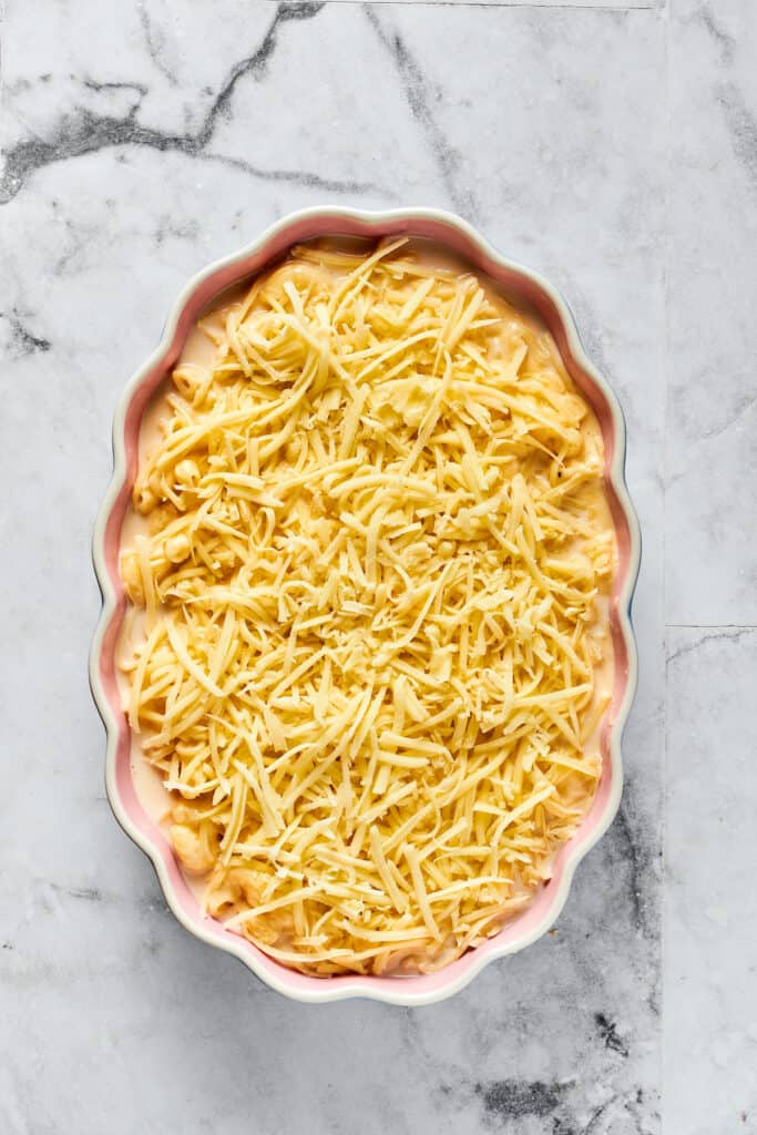 Unbaked macaroni topped with shredded mozzarella.