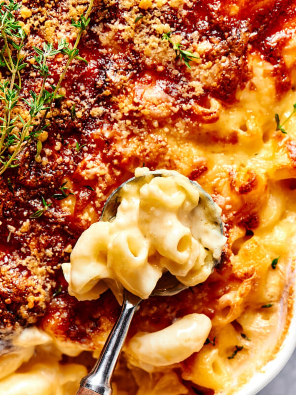 Spooning baked macaroni out of a casserole dish.