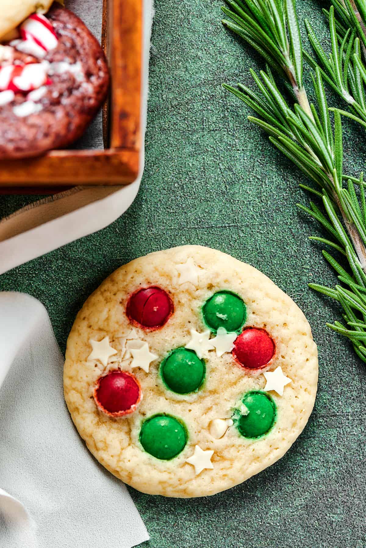 A Christmas sugar cookie decorated with white chocolate stars and M&Ms.