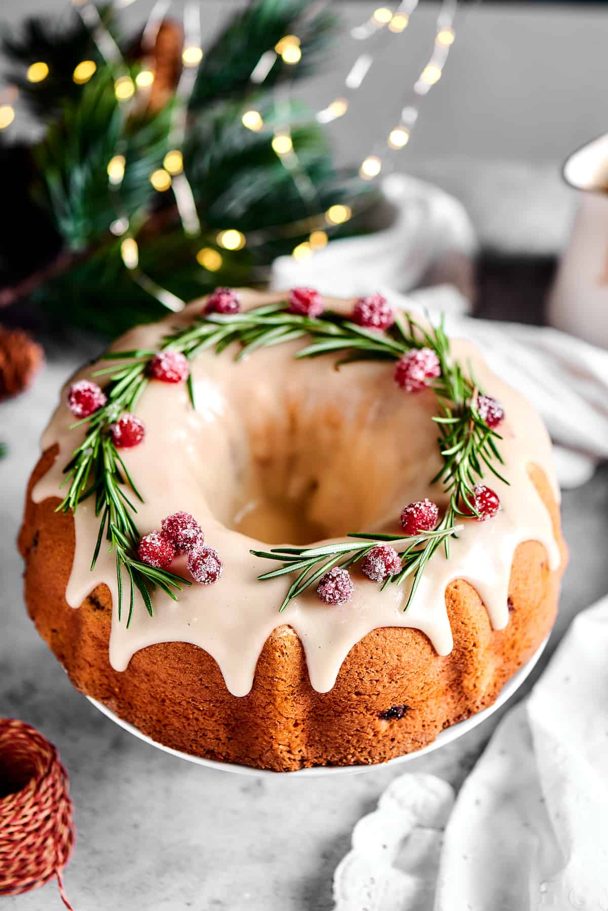 Overhead shot of a Bundt cake garnished with rosemary and sugared cranberries.
