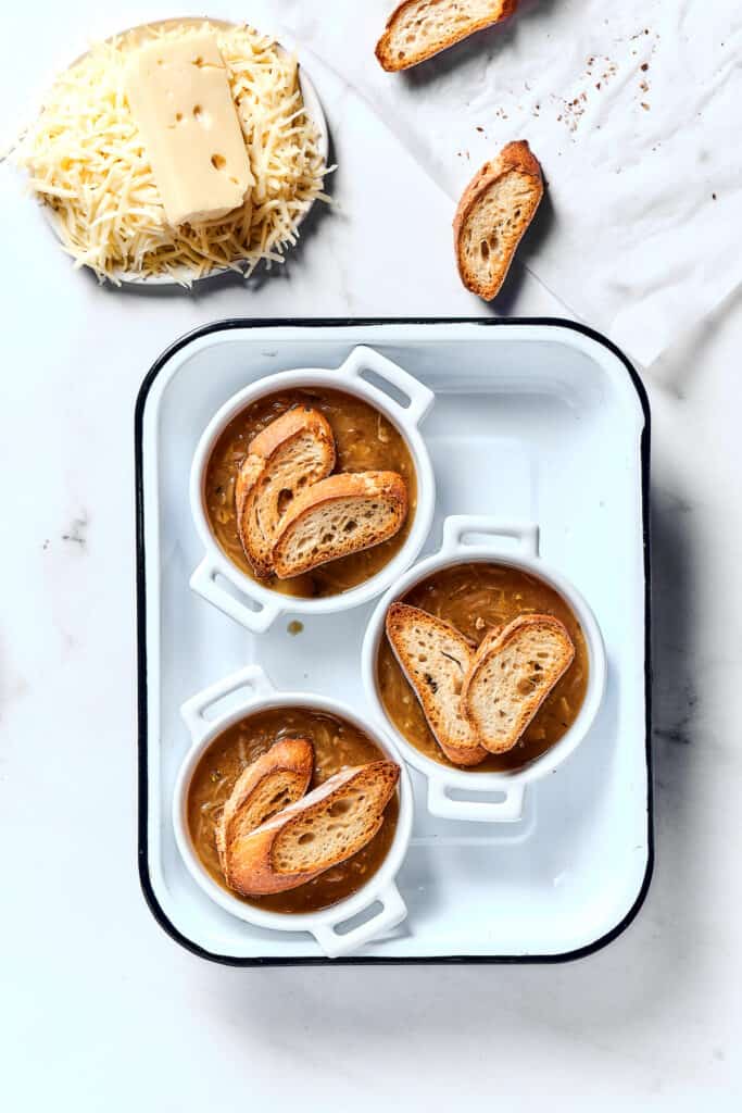 Individual oven-proof bowls of soup topped with toasted baguette.