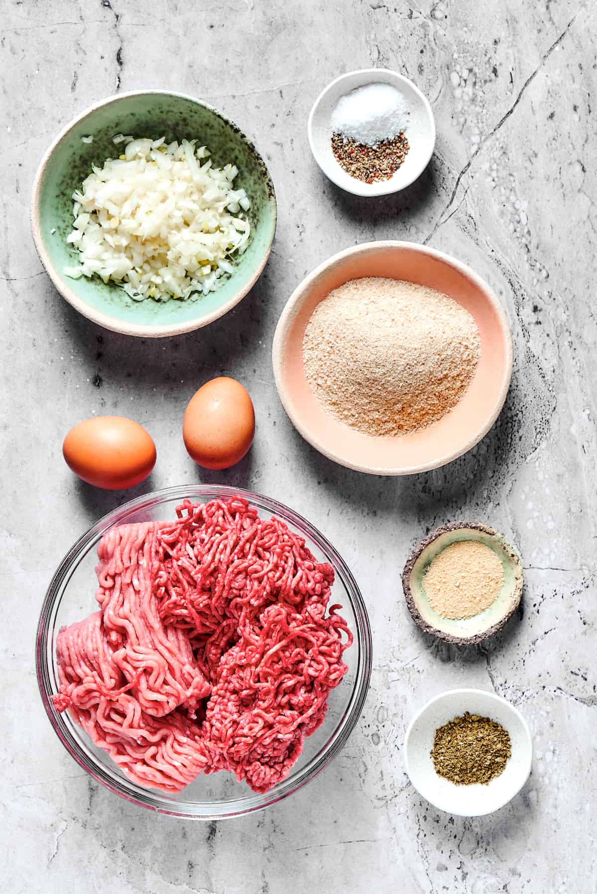 From top left: Onion, salt and pepper, eggs, breadcrumbs, ground beef and ground turkey, garlic powder, Italian seasoning.