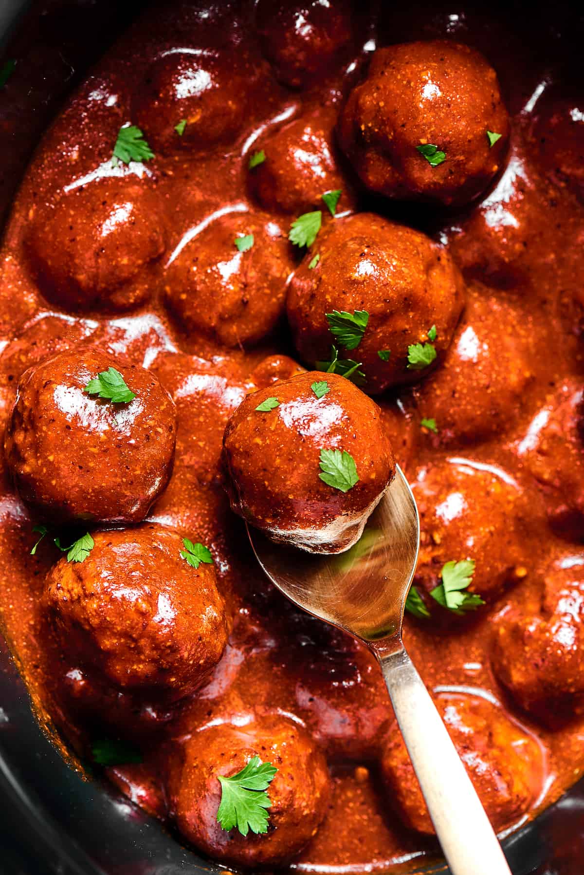 Meatballs in sauce, sprinkled with parsley.