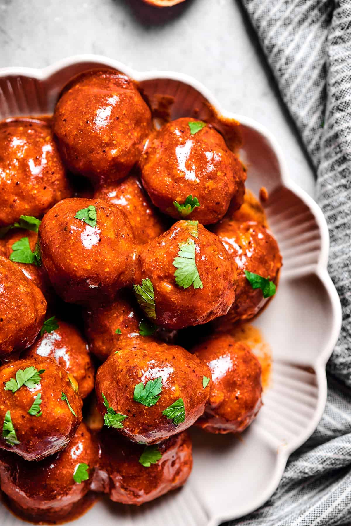 Saucy meatballs on a platter sprinkled with parsley.