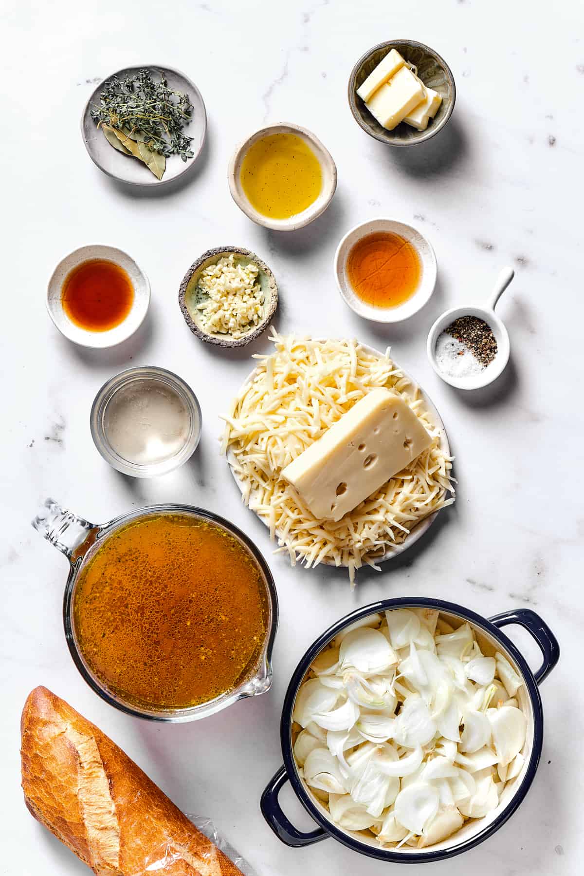 Ingredients for French onion soup arranged on a work surface.