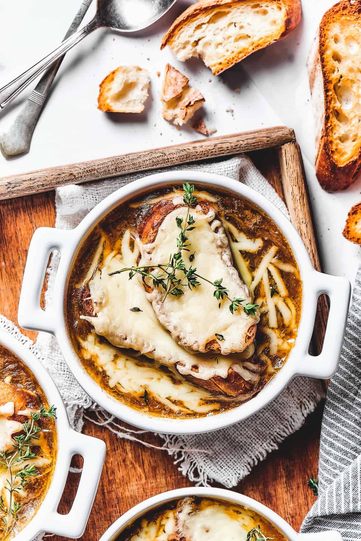 Double-handled bowls of French onion soup on a tray.