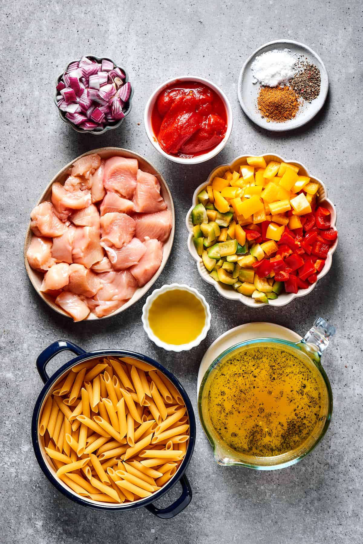 Chicken fajita pasta ingredients measured and arranged in small dishes on a work surface.