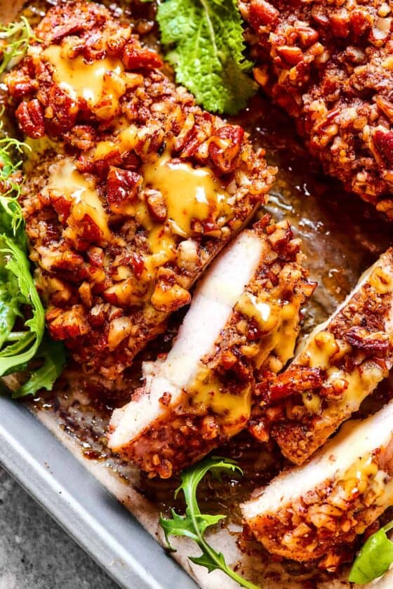 overhead photo of pecan crusted chicken, topped with honey mustard sauce, and sliced.