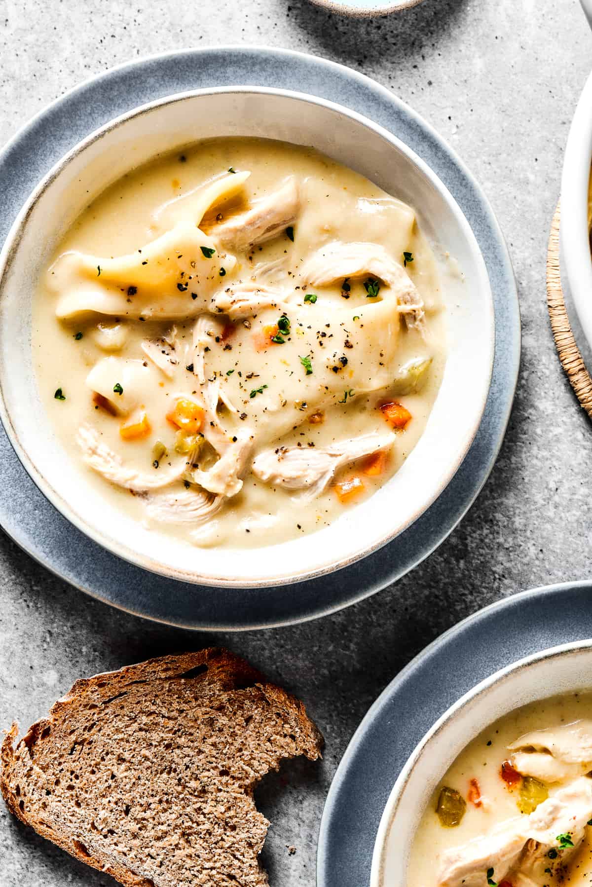 Creamy chicken and dumplings served into bowls.