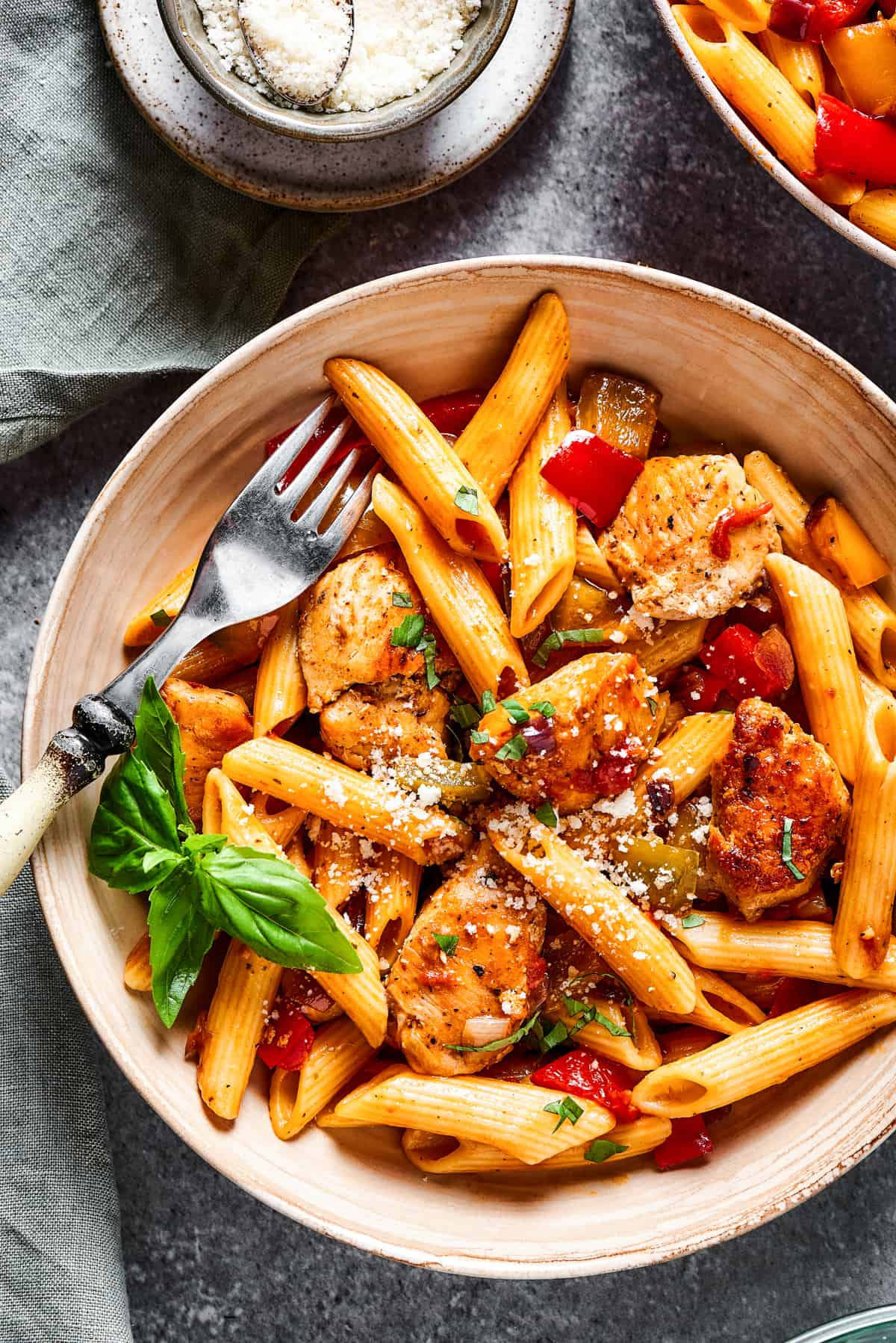 A bowl of chicken and pasta with a fork.